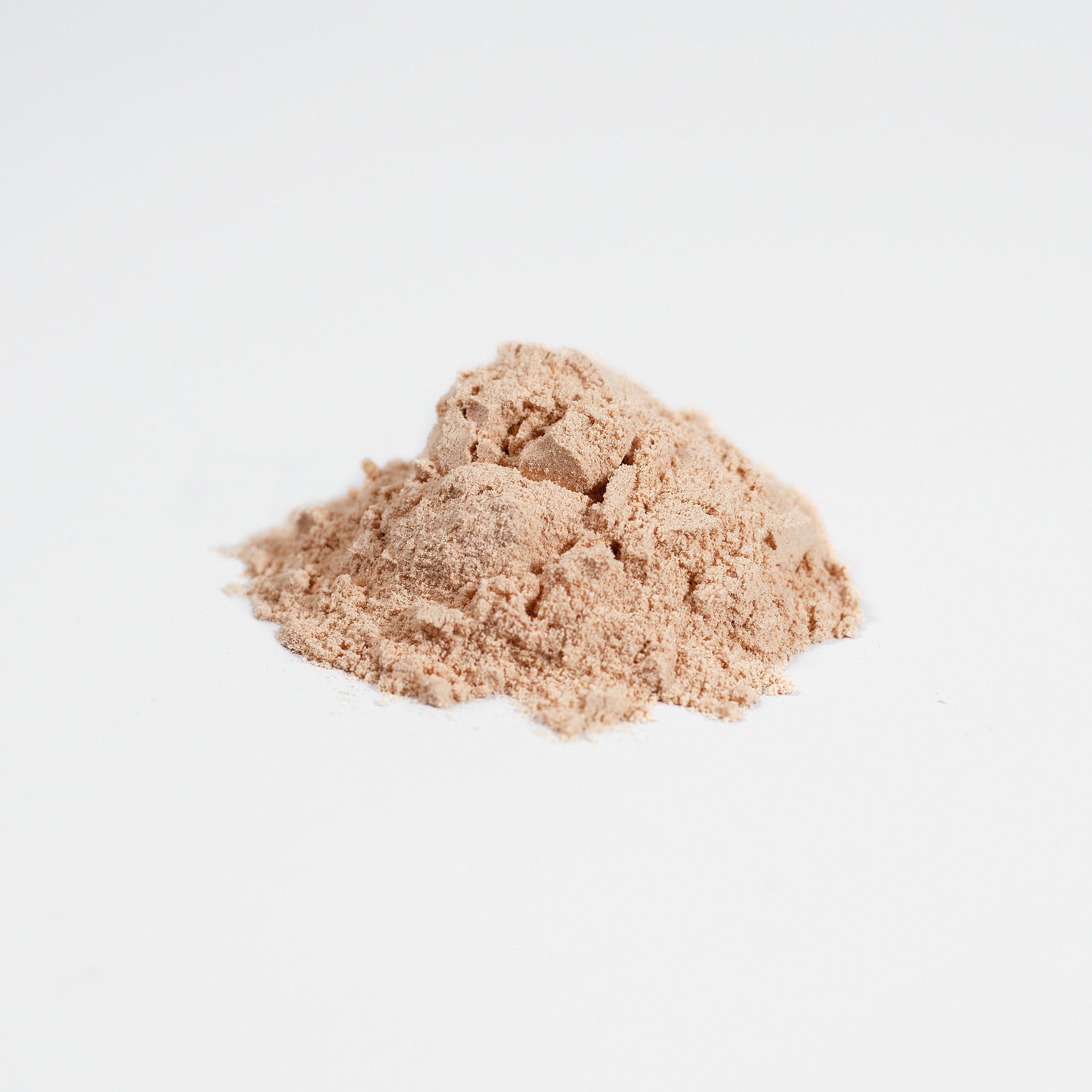 Two mounds of beige powder on a light gray background